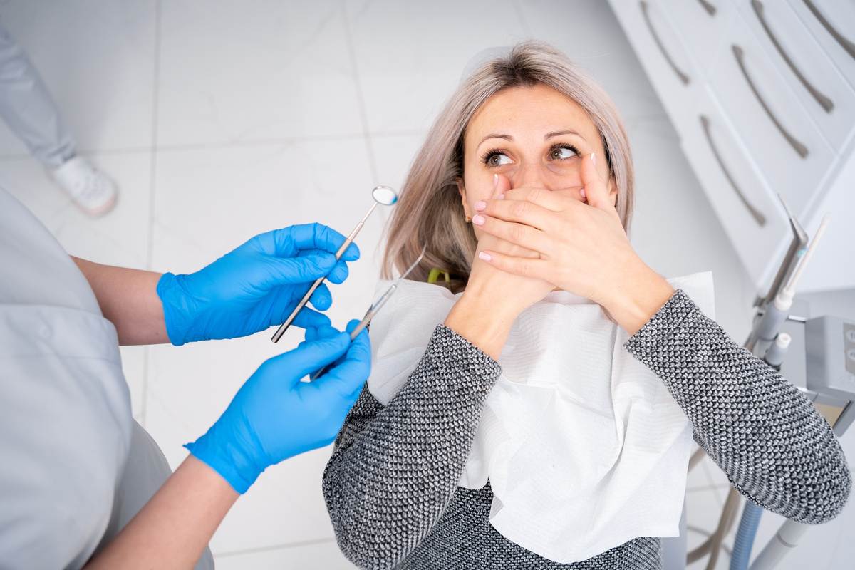 Fear of the dentist or fear of the doctor. Frightened and nervous patient woman in the hospital. Upset lady with phobia having panic attack in clinic before medical operation.